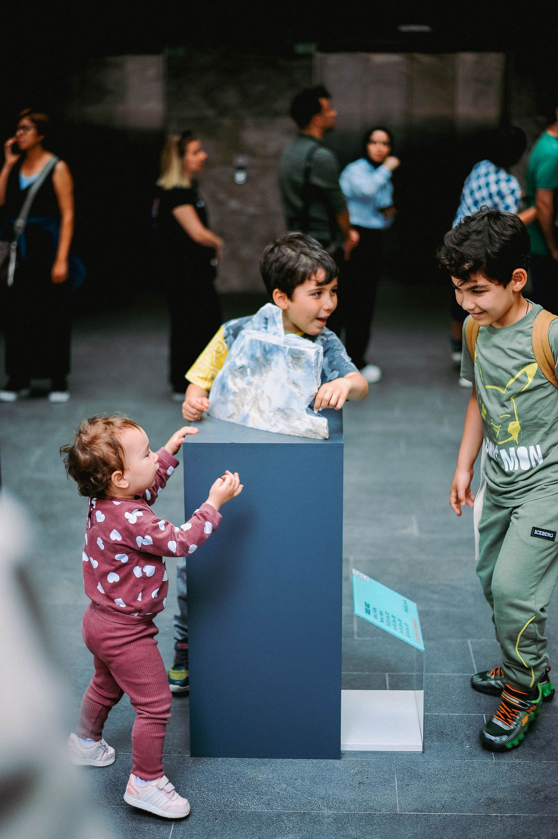 Three children exploring a hands-on museum exhibit together